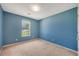 Empty bedroom with carpet, window, and blue painted walls is waiting for a personal touch at 424 Yellow River Walk, Lawrenceville, GA 30043