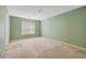 Spacious bedroom featuring green walls, carpet flooring, and a large window at 424 Yellow River Walk, Lawrenceville, GA 30043