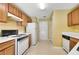 Traditional kitchen featuring wooden cabinets, white appliances, and a gas range at 424 Yellow River Walk, Lawrenceville, GA 30043