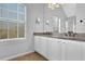 Modern bathroom featuring double vanity, granite countertop, and plenty of natural light at 5030 Mundy Dr, Cumming, GA 30028