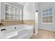 Bathroom featuring a soaking tub with tiled surround and a large window at 5030 Mundy Dr, Cumming, GA 30028