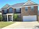 Charming two-story brick home with a well-manicured lawn, two-car garage, and inviting entrance at 5030 Mundy Dr, Cumming, GA 30028