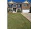 Two story brick home featuring a well manicured front yard and attached two car garage at 5030 Mundy Dr, Cumming, GA 30028