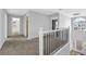 An upstairs hallway with carpet, white trim and iron balusters at 5030 Mundy Dr, Cumming, GA 30028