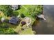 Aerial view of a lakeside property with a patio, fire pit, dock, and lush landscaping at 625 W Lake Dr, Oxford, GA 30054