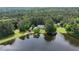 Aerial view of a lakeside home surrounded by lush greenery, featuring a private dock and serene water views at 625 W Lake Dr, Oxford, GA 30054