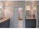 Bathroom featuring double vanities, neutral tile floor, and modern lighting at 625 W Lake Dr, Oxford, GA 30054
