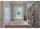Relaxing bathroom with soaking tub, stained glass window, and nautical decor at 625 W Lake Dr, Oxford, GA 30054