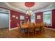 Formal dining room with wooden table, red walls and hardwood floors at 625 W Lake Dr, Oxford, GA 30054
