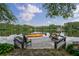 A private dock featuring lounge seating and a kayak, offering serene waterfront views on a tranquil lake at 625 W Lake Dr, Oxford, GA 30054