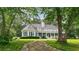 Backyard view of a home with a large sunroom, a full-length porch, and lush greenery for a peaceful retreat at 625 W Lake Dr, Oxford, GA 30054