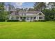Expansive view of the home's exterior with a large front lawn and mature trees at 625 W Lake Dr, Oxford, GA 30054