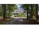 Beautiful home framed by mature trees, featuring a welcoming front porch and a driveway leading to a peaceful retreat at 625 W Lake Dr, Oxford, GA 30054