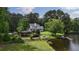 Charming home with lake access, featuring a spacious lawn, covered patio, and a private dock for waterfront enjoyment at 625 W Lake Dr, Oxford, GA 30054
