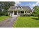 Welcoming home exterior featuring a charming front porch and beautifully landscaped lawn at 625 W Lake Dr, Oxford, GA 30054