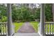Inviting view from the front porch, showcasing the driveway, manicured lawn, and serene wooded surroundings at 625 W Lake Dr, Oxford, GA 30054