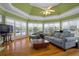 Sunroom with green walls, hardwood floors, fan, large windows, and comfortable seating at 625 W Lake Dr, Oxford, GA 30054