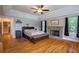 Main bedroom with a stone fireplace, decorative trim, hardwood floors and natural light at 625 W Lake Dr, Oxford, GA 30054