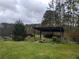 Outdoor kitchen space with a covered pergola, outdoor grill, and lake views at 625 W Lake Dr, Oxford, GA 30054