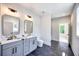 Modern bathroom featuring double vanity with stone countertop, sleek fixtures, and dark tile flooring at 2110 Fairway Ne Cir, Brookhaven, GA 30319