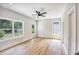 Spacious bedroom with light wood floors, neutral walls, a ceiling fan, and large windows overlooking the neighborhood at 2110 Fairway Ne Cir, Brookhaven, GA 30319