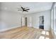 Spacious bedroom with light wood floors, neutral walls, ceiling fan, and multiple doors for easy access to other rooms at 2110 Fairway Ne Cir, Brookhaven, GA 30319