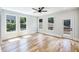 Bright and airy bedroom with light wood floors, white trim, a ceiling fan, and three large windows for ample natural light at 2110 Fairway Ne Cir, Brookhaven, GA 30319