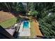 Aerial view of a backyard with in-ground pool surrounded by lush landscaping and mature trees at 2110 Fairway Ne Cir, Brookhaven, GA 30319
