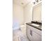 Stylish powder room featuring a gray vanity with black countertop and backsplash, marble tile floor, and modern fixtures at 2110 Fairway Ne Cir, Brookhaven, GA 30319