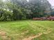 View of the backyard with trees and piles of brush for removal at 2226 Upper Burris Rd, Canton, GA 30114