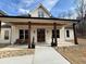 Inviting front porch with stone accents, wooden columns and double entry doors at 2226 Upper Burris Rd, Canton, GA 30114