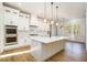 Modern kitchen with a large island, stainless steel appliances, white cabinetry, and hardwood floors at 2226 Upper Burris Rd, Canton, GA 30114