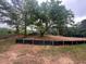 Cleared homesite featuring a large, mature tree, silt fencing, and a view of surrounding trees at 2226 Upper Burris Rd, Canton, GA 30114