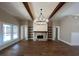 Spacious living room with stone fireplace, wood beams, hardwood floors and modern lighting fixture at 2226 Upper Burris Rd, Canton, GA 30114