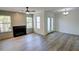 Bright living room with a fireplace, a ceiling fan, luxury vinyl plank flooring, and updated lighting at 3263 Long Iron Pl, Lawrenceville, GA 30044