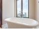Modern soaker tub with chrome fixtures and skyline view at 3376 Peachtree Ne Rd # 35A, Atlanta, GA 30326