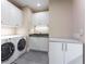 Bright laundry room featuring front loading washer/dryer, gray tile floors, and ample storage space at 3376 Peachtree Ne Rd # 35A, Atlanta, GA 30326