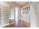Organized walk-in closet with custom shelving, mirrored doors, and hardwood floors at 3376 Peachtree Ne Rd # 35A, Atlanta, GA 30326