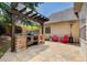 Backyard patio featuring stone outdoor kitchen with a built-in grill and room for entertaining at 5220 Wild Cedar Dr, Buford, GA 30518