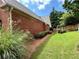 Landscaped backyard featuring healthy lawn, mature shrubs, and wood fencing at 5220 Wild Cedar Dr, Buford, GA 30518