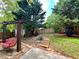 Backyard featuring hanging porch swing, stone steps, privacy fence, and mature trees at 5220 Wild Cedar Dr, Buford, GA 30518