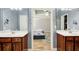 A bright main bathroom with dual sinks and vanity with a view into the main bedroom at 5220 Wild Cedar Dr, Buford, GA 30518