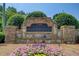 Stone entrance sign for Wildwood community, surrounded by manicured landscaping and colorful flowers at 5220 Wild Cedar Dr, Buford, GA 30518
