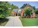 Charming two-story brick home with manicured lawn and mature trees, providing curb appeal at 5220 Wild Cedar Dr, Buford, GA 30518
