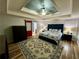 Spacious main bedroom with a tray ceiling, elegant furnishings, and a decorative area rug at 5220 Wild Cedar Dr, Buford, GA 30518