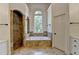 Bright bathroom featuring a bathtub, tiled shower, neutral paint, large window, and tile flooring at 7920 Tintern Trce, Duluth, GA 30097