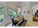 Dining room featuring a wood table, bench, and large windows overlooking backyard at 7920 Tintern Trce, Duluth, GA 30097