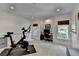 Bright exercise room featuring an exercise bike and adjacent office nook at 7920 Tintern Trce, Duluth, GA 30097