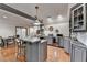 Stylish kitchen bar area with pendant lights, seating, dining area, and modern appliances at 7920 Tintern Trce, Duluth, GA 30097