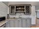 Kitchen storage area with gray cabinets, wine racks, and white brick accent wall at 7920 Tintern Trce, Duluth, GA 30097